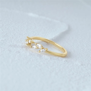 Macro shot of S925 sterling silver gold-plated ring with leaf motifs and white zircons