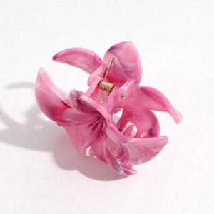 Detailed macro view of pink marble floral hair claw with strong golden metal spring