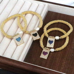 Classic gold beaded bracelets with heart pendants, pearls and crystals in a jewelry box