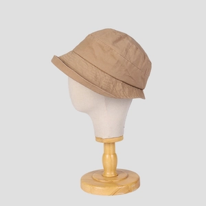 Close-up of khaki cotton bucket hat with reinforced stitching on wooden head stand