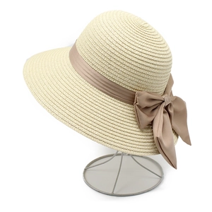Détails de texture d'un chapeau de paille beige avec élégant ruban en satin marron