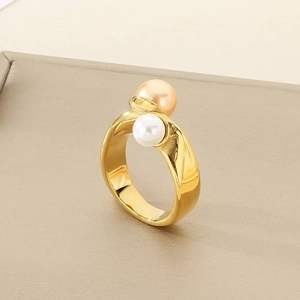 Macro detail of gold textured geometric ring with white and champagne pearls on a stand