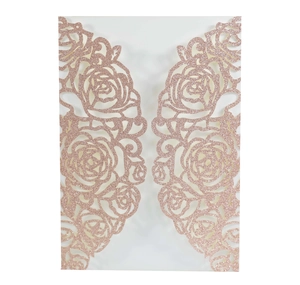 Detailed macro view of laser-cut rose gold glitter wedding invitation with floral patterns