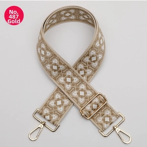 Close-up of geometric jacquard woven bag strap with gold metal swivel snap hooks