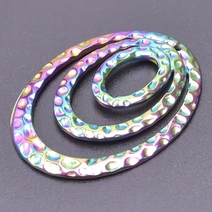 Macro detail of triple-layered oval DIY metal charms with rainbow plated hammered texture
