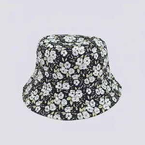 Detailed close-up of floral bucket hat with white flower pattern and green leaves