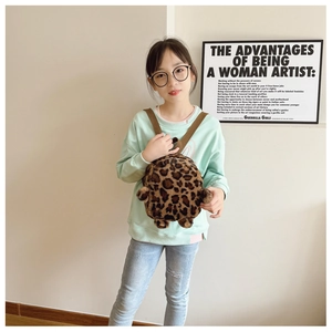 Detail of plush leopard print mini backpack shown on a child in a clean indoor setting