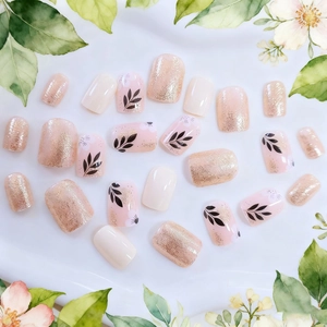 Short square press-on nails with floral leaf patterns and champagne gold glitter