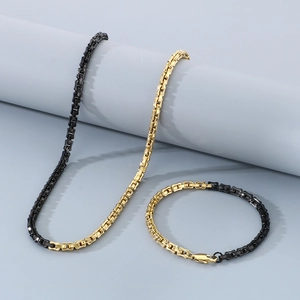Detailed view of black and gold bamboo-style chain link necklace and bracelet set