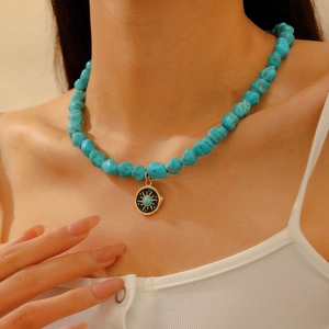 Bohemian turquoise beaded necklace with gold sun evil eye pendant on model neck