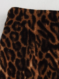 Detailed close-up of leopard print velvet fabric showing soft texture and stitching