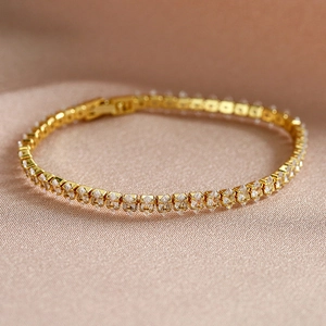 Makroaufnahme der Gold-Tennisarmband mit funkelnden Marquise-Zirkonia auf Textil