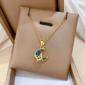 Detail of a gold butterfly on a blue moon pendant set in a luxury jewelry box