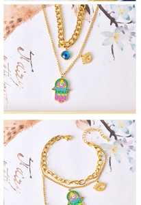 Macro detail of gold evil eye and hamsa pendants on a multi-layer necklace set