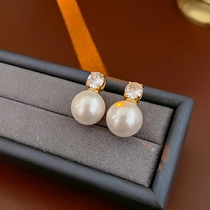 Gros plan de boucles d'oreilles perles avec zircons sur un coffret à bijoux en velours gris