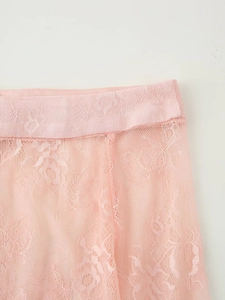 Detailed macro view of delicate pink floral lace fabric and refined waist stitching