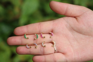 Close-up of star and moon earrings with colorful zircon stones in four vibrant colors