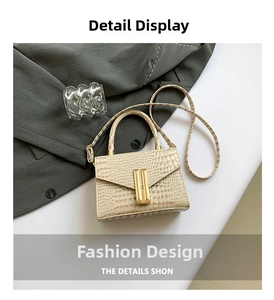 Detail view of cream crocodile textured crossbody bag featuring a golden rectangular lock