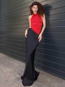 Détail du haut dos nu rouge avec ourlet irrégulier et jupe longue en satin noir chic