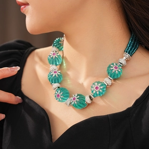 Detail of vintage turquoise beaded necklace with pink gemstone accents on model