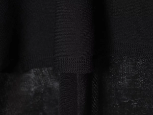 Close-up of black knit fabric texture showing tight weave and breathable mesh details