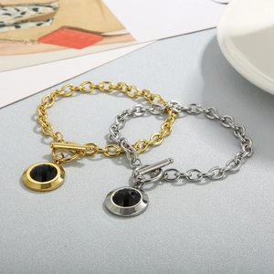 Gros plan de bracelets en acier titane or et argent avec cristaux noirs et boucle OT