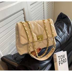 Detailed shot of cream quilted leather bag with gold chain strap and metal lock