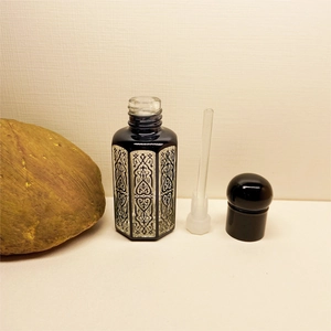 Detail of blue hexagonal crystal essential oil bottle with vintage silver relief texture