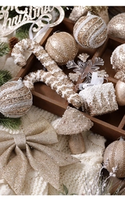 Detailed assortment of champagne and white glitter ornaments in a rustic wooden tray