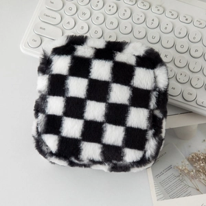 Gros plan sur la trousse à maquillage en peluche à damier noir et blanc au toucher doux