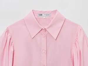 Close-up of pink poplin shirt collar with pleat details and brand label on neck