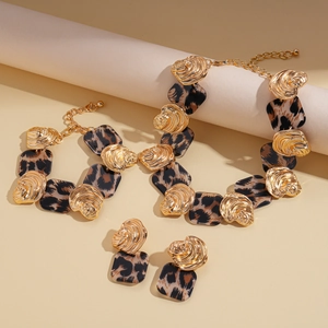 Macro detail of leopard print resin plates and golden shell clasps on a jewelry set