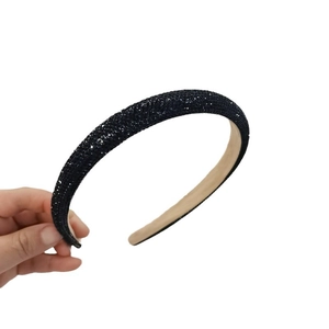 Elegant wide headband featuring dense black rhinestones and a soft beige inner lining