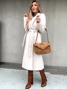 Detail of off-white long wool coat with large lapel and waist tie on a model