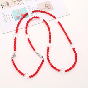 Detail of red acrylic beaded chain with transparent hearts and metallic clasps