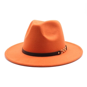 Detail of bright orange wool fedora hat featuring a black leather band and gold chain buckle