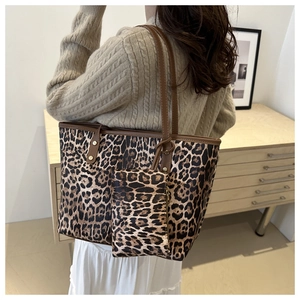 Detailed view of leopard print tote bag with matching pouch shown in a home setting