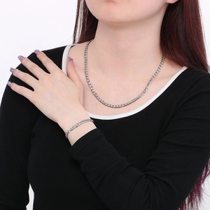Classic silver stainless steel Cuban link necklace and bracelet set worn by a male model
