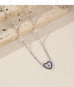 Macro detail of S925 silver heart necklace with blue and white pavé setting