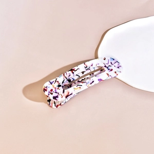 Detail of a rectangle cellulose acetate barrette with colorful terrazzo patterns and textures