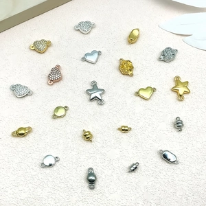 Flat lay of heart and star magnetic jewelry clasps in gold and silver finishes