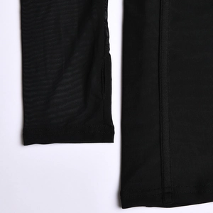 Gros plan sur tissu en maille noire avec détail de trou pour le pouce et couture fine