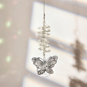 Detailed macro view of faceted crystal ball and silver butterfly metal pendant on suncatcher