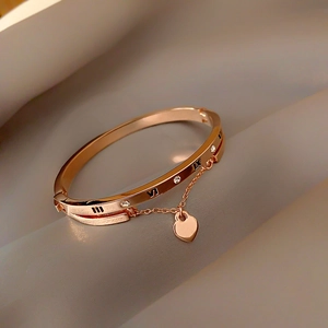 Detailed macro of rose gold bracelet with roman numerals, crystals and heart charm