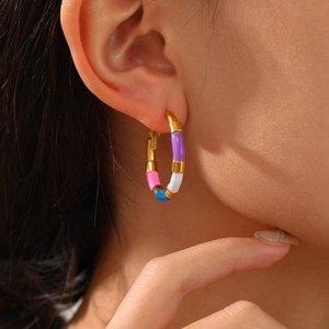 Boucles d'oreilles créoles émaillées colorées en acier doré 18K portées par mannequin