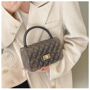 Detail of transparent black quilted jelly bag with bead handle and gold chain strap