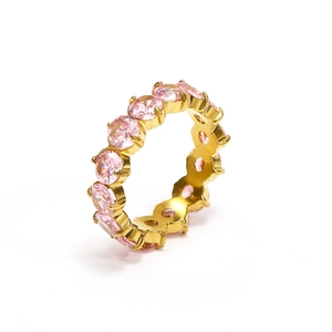 Detailed close-up of eternity band ring with pink cubic zirconia stones in gold plating