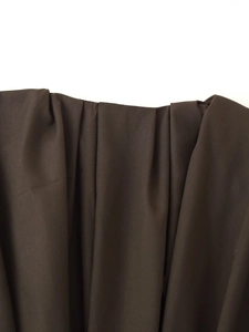 Detail view of deep brown pleated fabric with draped waist texture for women dress