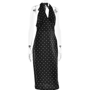 Détail d'une robe licou noire à pois avec dos nu et texture de tissu satiné brillant