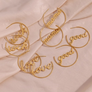 Flat lay of gold hoop earrings with rock mama good love lettering on pink silk